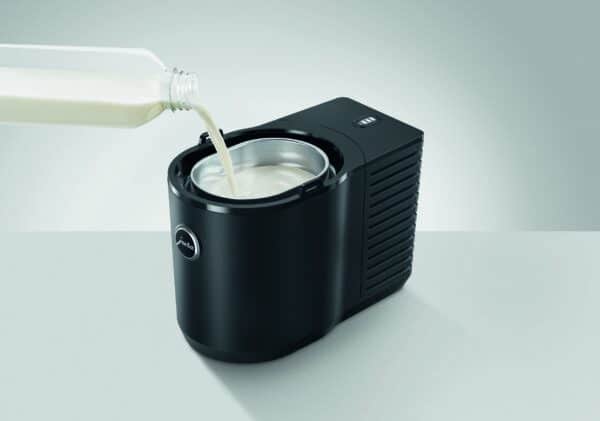 Milch wird in den Jura Cool Control 1,0 l gegossen