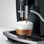 Jura E6 Piano Black bereitet Cappuccino mit Milchschaum zu – Caffista Sindelfingen