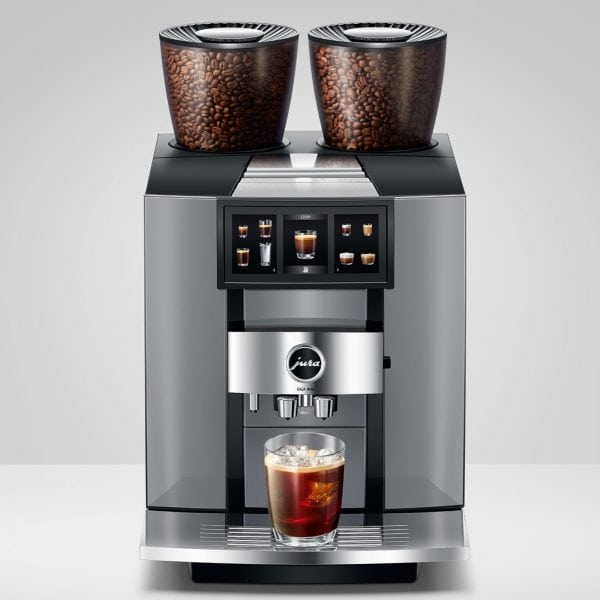 JURA GIGA W10 mit zwei Bohnenbehältern und einem Glas in der Frontansicht