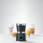 Milchschaum aus Jura Milchaufschäumer wird in Latte-Glas gegossen