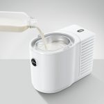 Frische Milch wird in den Jura Cool Control Weiß gegossen