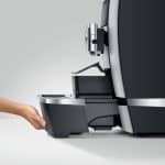 Hand entnimmt die Tropfschale und den Kaffeesatzbehälter der JURA GIGA X3c