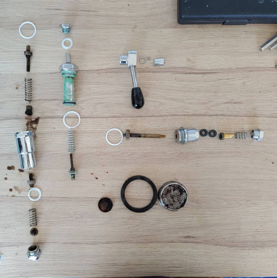 Die ausgebauten Teile der E61 Brühgruppe zeigen deutliche Gebrauchsspuren und Verschleiß