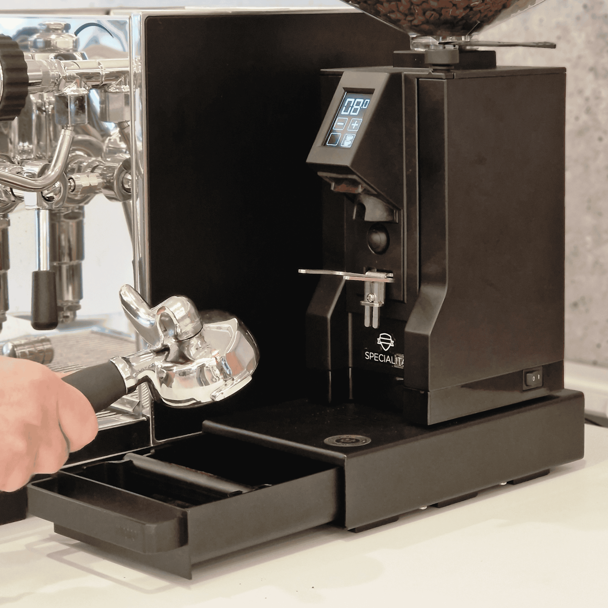 Barista klopft Siebträger auf EUREKA Knock Box Drawer Schwarz ab