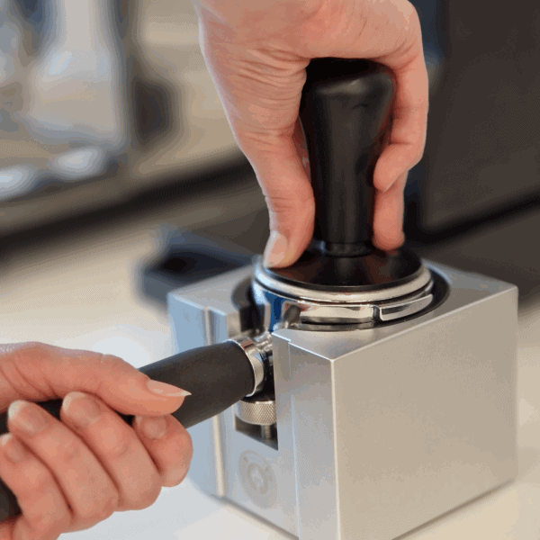 Barista nutzt EUREKA Druck Tamper 58 mm für gleichmäßiges Tamping