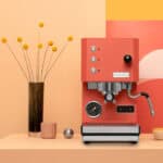 Profitec GO Red Espressomaschine mit Siebträger auf Tisch mit roter Vase – Caffista Sindelfingen