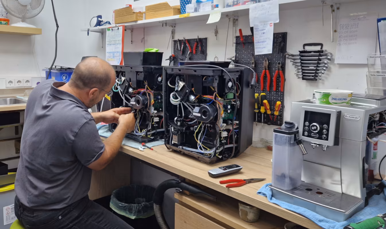 Ein Caffista Techniker bei der Reparatur eines Kaffeevollautomaten in der angeschlossenen Fachwerkstatt.